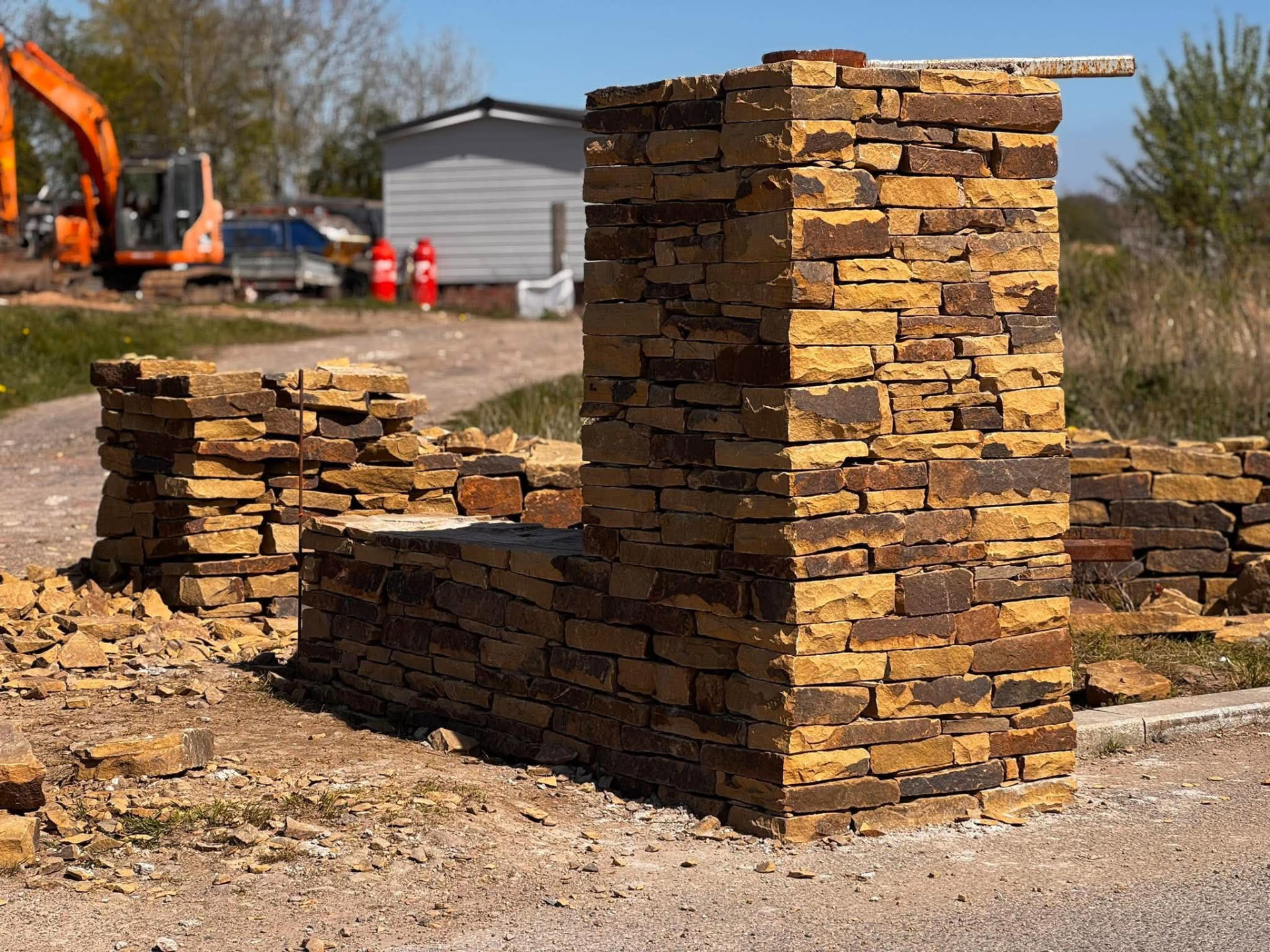 Newly built sandstone pillar and low wall on a construction site